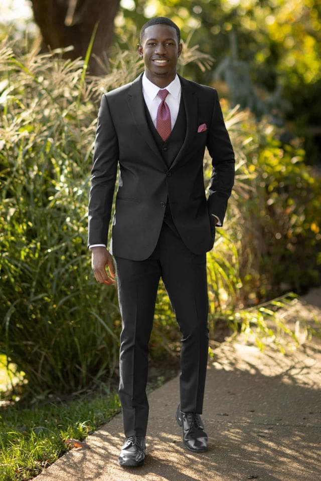 Picture of man in black tux in front of trees